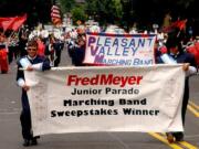 Battle Ground: Chase Lund, left, and Melissa Huynh carry the Pleasant Valley Middle School marching band banner in the 2010 Rose Festival Fred Meyer Junior Parade.