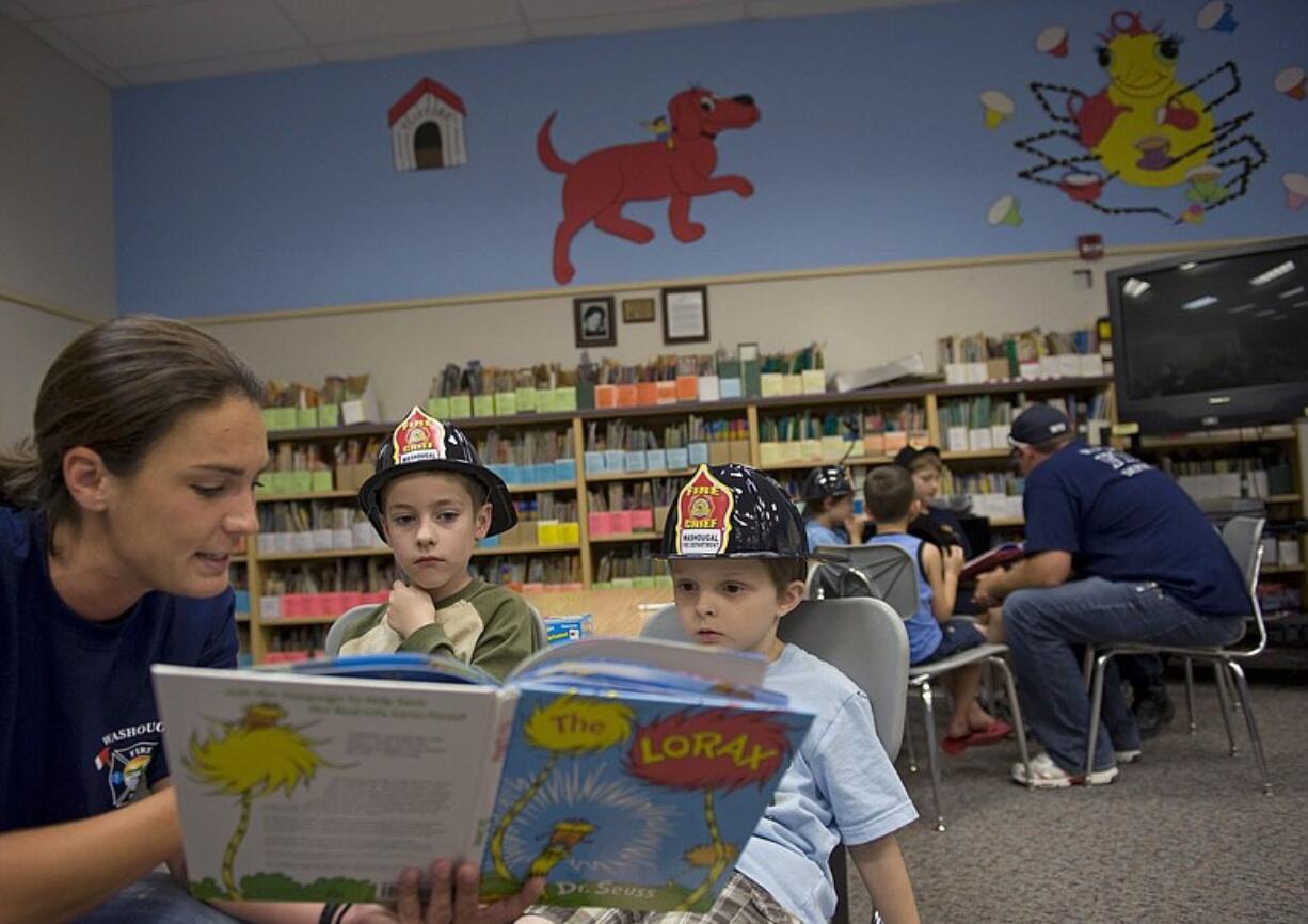 Washougal Firefighter Carly Shears reads &quot;The Lorax&quot; by Dr. Seuss to first-graders Spencer Nicholson, center, and Riley Gardner. On Thursday, firefighters visited the 20 students who are participating in a six-week summer literacy program at Hathaway Elementary School.