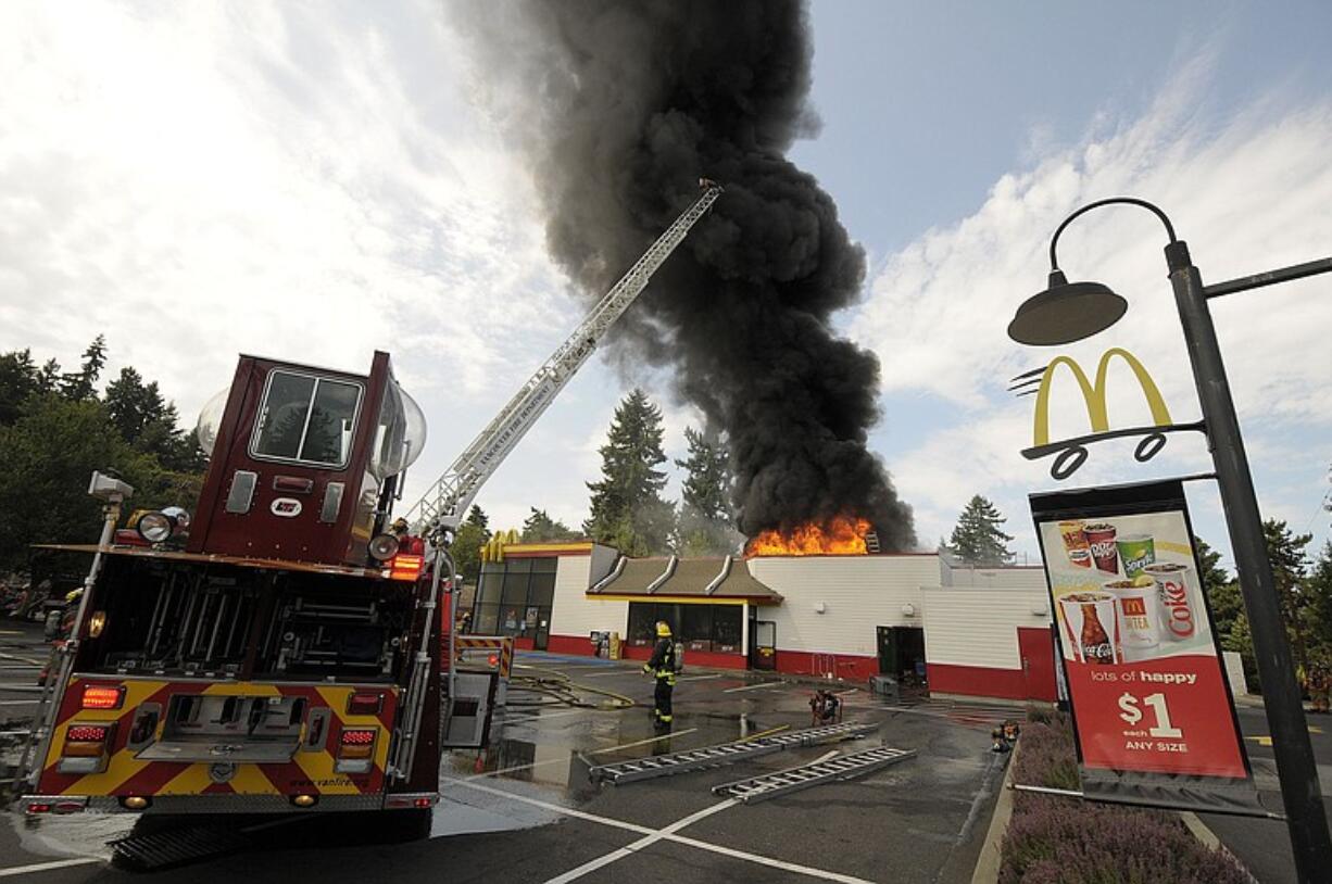 Vancouver firefighters provide initial attack on a fire at the Rose Village McDonald's shortly before noon today.