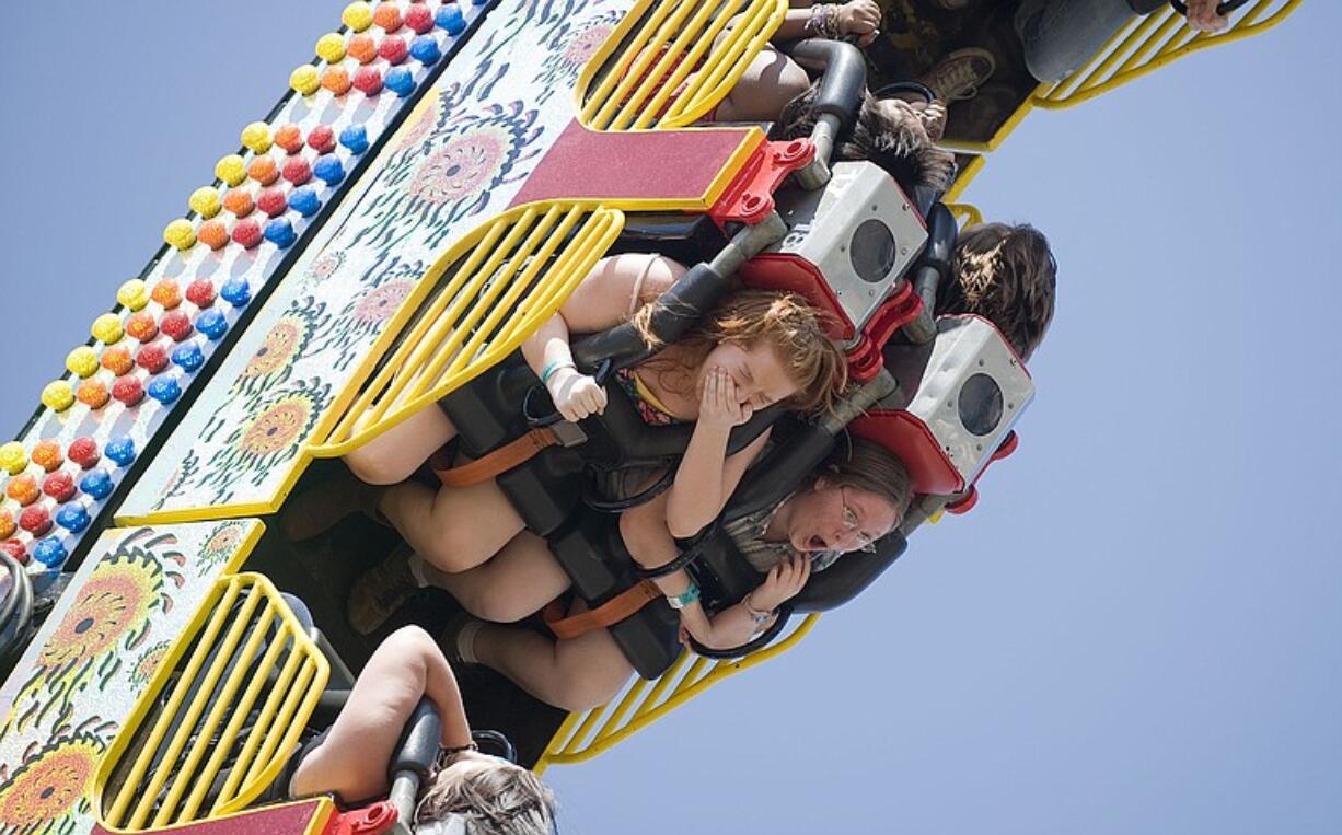 Alyssa Dawkins, 17, of Vancouver, covers her mouth as she rides the Ring of Fire on the first day of the Clark County Fair on Friday.