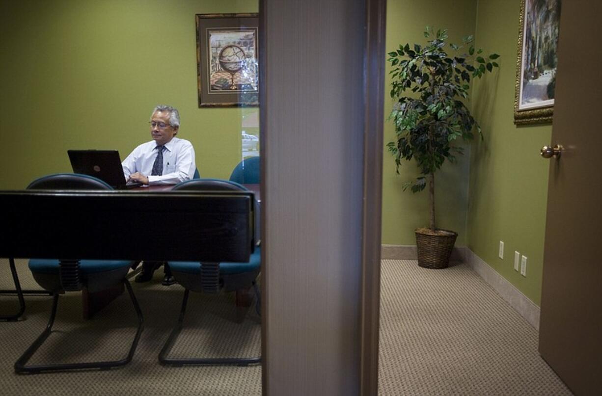 Attorney Enrico Tadeo, a virtual tenant at Executive Center Northwest, works on his computer before meeting with a client.