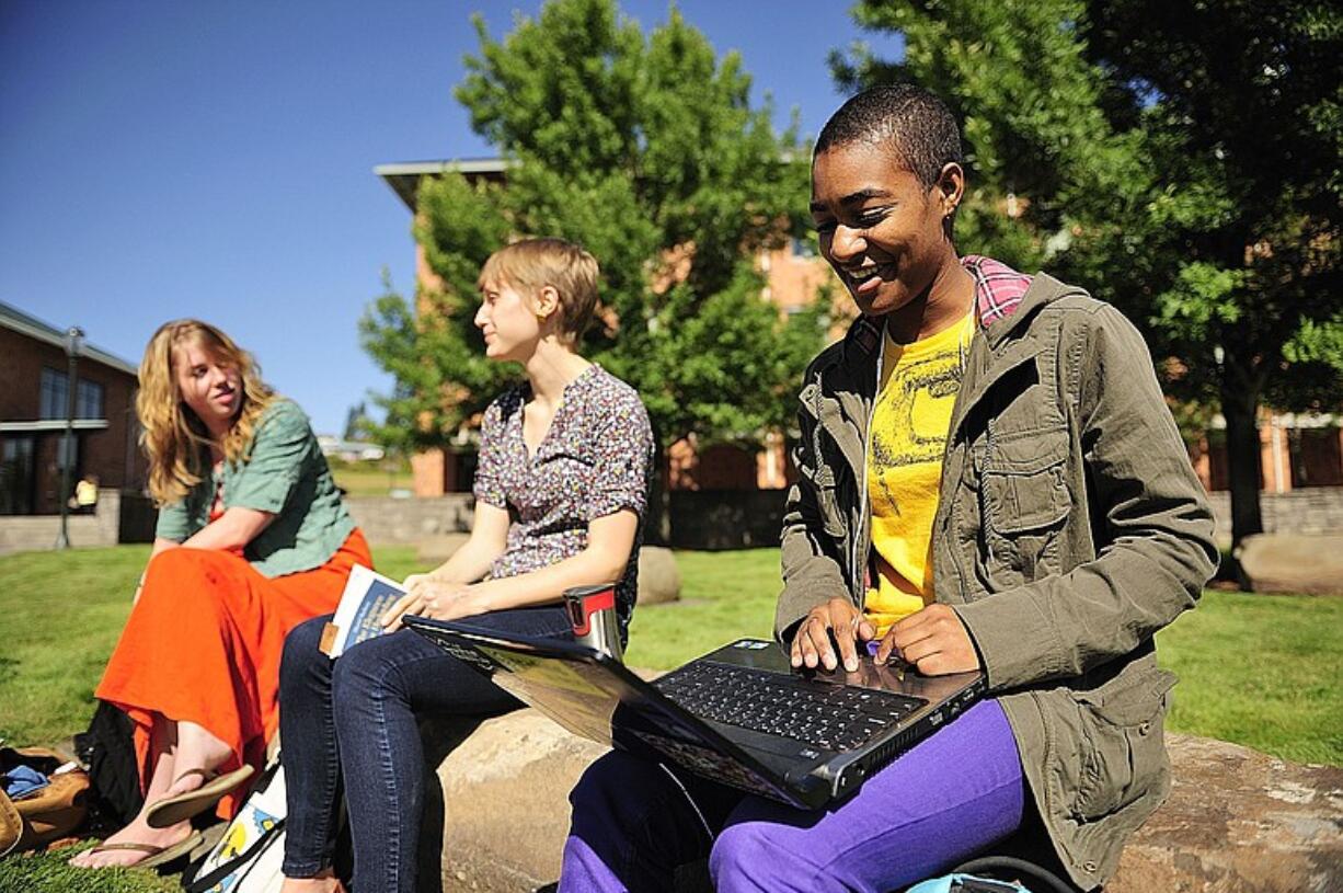 Vancouver School of Arts and Academics alumnae Andrea Crawford, from left, Anna Mathes and Keziah Richards take a break at Washington State University Vancouver between classes on Monday morning.