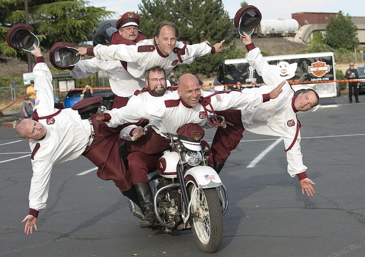 Fuzzy Jamison, center  riding the bike, supports five  members of team.