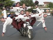 Fuzzy Jamison, center  riding the bike, supports five  members of team.