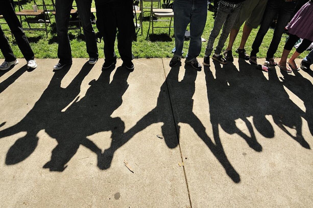 People gather and hold hands as singer and songwriter Noah sings his song &quot;Now More Than Ever&quot; as part of Monday's Oxfest celebration at Esther Short Park.