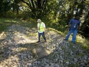 WSUV grounds specialist John Benson and facilities operations director James Martin stand atop the top end of a drain that will settle out silt through a series of a dozen rock gabions below.