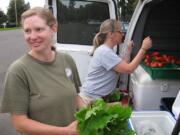 April Jones, an organic CSA farmer from Ridgefield, left, distributes fresh produce to Fruit Valley resident Michelle May.