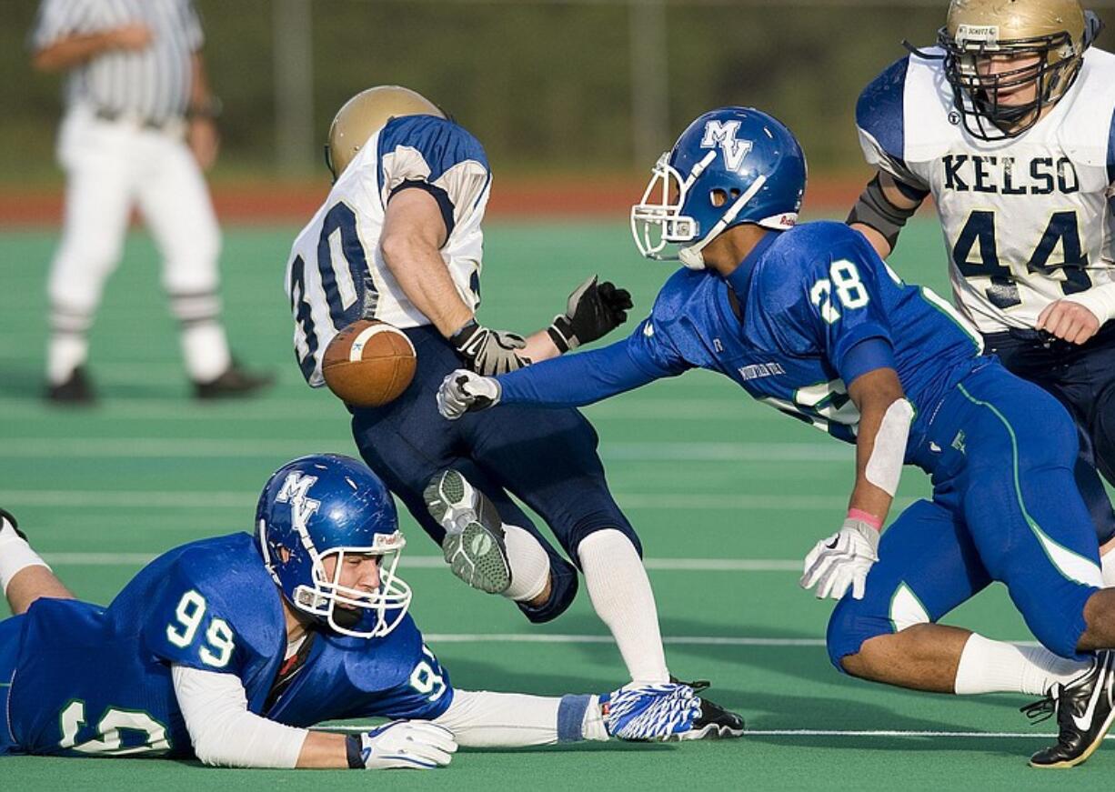 Mountain View's P.J. Jones (28) swats the ball from Kelso ball carrier Riley Miller (30) during Friday's 3A Greater St. Helens League game at McKenzie Stadium.