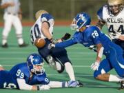 Mountain View's P.J. Jones (28) swats the ball from Kelso ball carrier Riley Miller (30) during Friday's 3A Greater St. Helens League game at McKenzie Stadium.