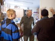 Firefighter Shawn Richey of Fire District 6, right, assisted by Paydenn Paull-Weston, left, replaces a smoke detector battery Saturday in the home of Stan Coleman, center, in Meadow Verde Mobile Home Park in Hazel Dell.