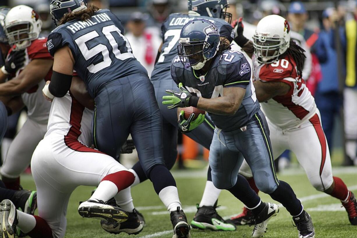 Seattle Seahawks' Marshawn Lynch (24) runs the ball against the Arizona Cardinals with the help of blocking from teammate Ben Hamilton (50) in the first half Sunday at Qwest Field.