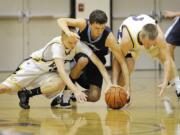 Eric Sjogren, left, and Kevin Cotter, right, of Columbia River High School attempt to steal a basketball from Joshua Hall, center, of Hockinson High School during a game Tuesday November 30, 2010 in Vancouver, Washington.