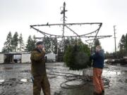 Will Barnes, left, and Rick Smith of DeWitt Construction make sure the Christmas tree and 6-foot-wide star are secure Wednesday before the 130-foot crane boom is raised.