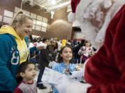 The Barbosas -- mom Lilly, from left, Nicholas, 3, and Aliyana, 8 -- meet Santa at the Community Youth Holiday Event at Sarah J.