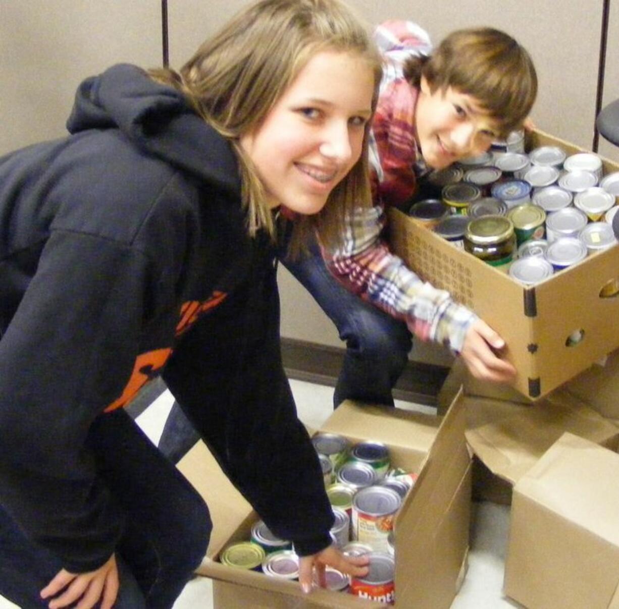 Chief Umtuch school: Erin Morse and Tristan Decker dig into cans of food.