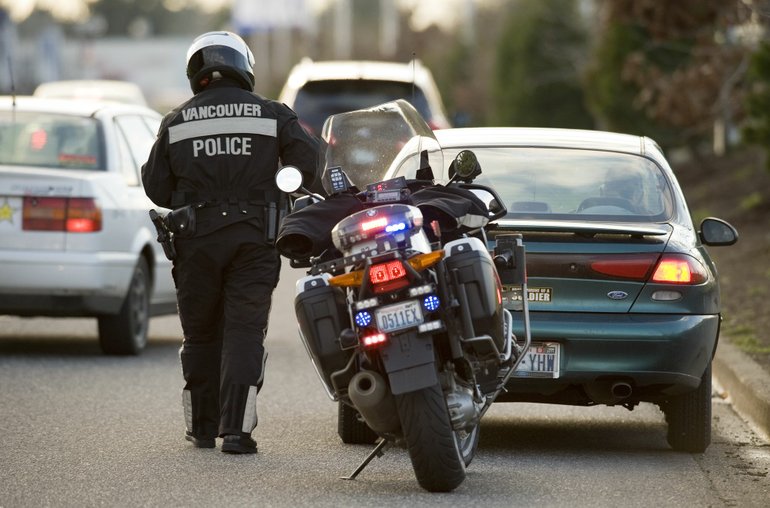 Vancouver Police Officer John Davis issues a speeding ticket to a driver.