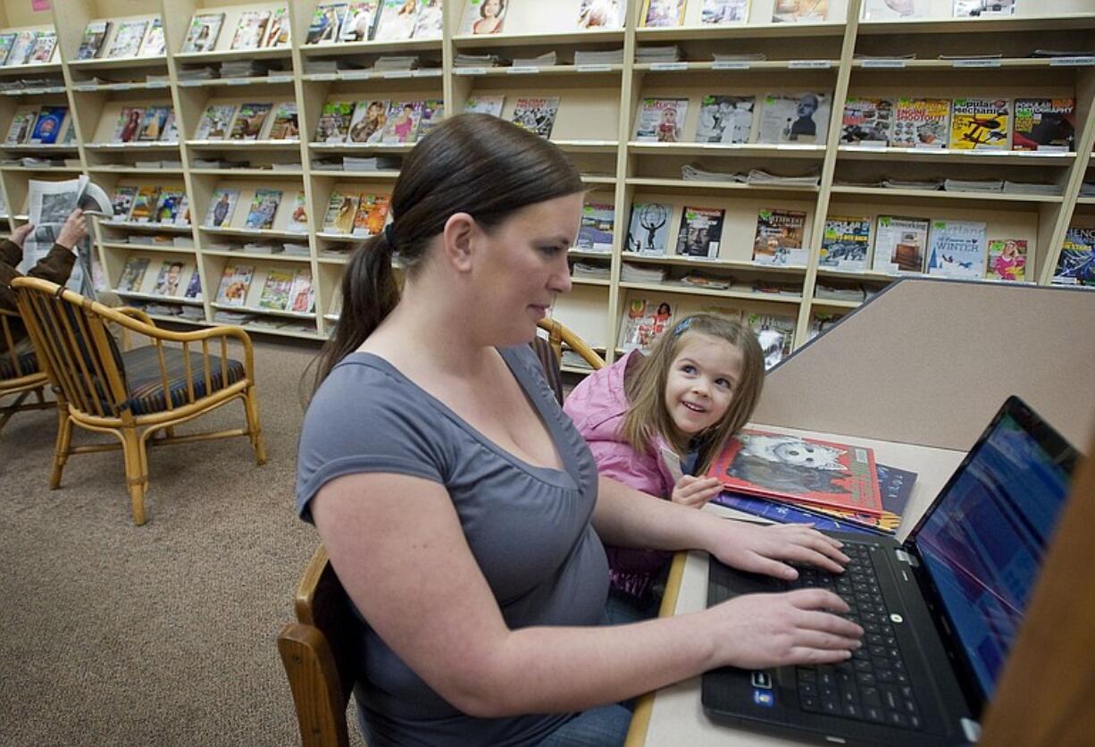 Emily Battles of Sifton surfs the Web on Sunday at the Vancouver Mall Community Library. Battles and her daughter, Edessa, selected three books for nighttime reading.