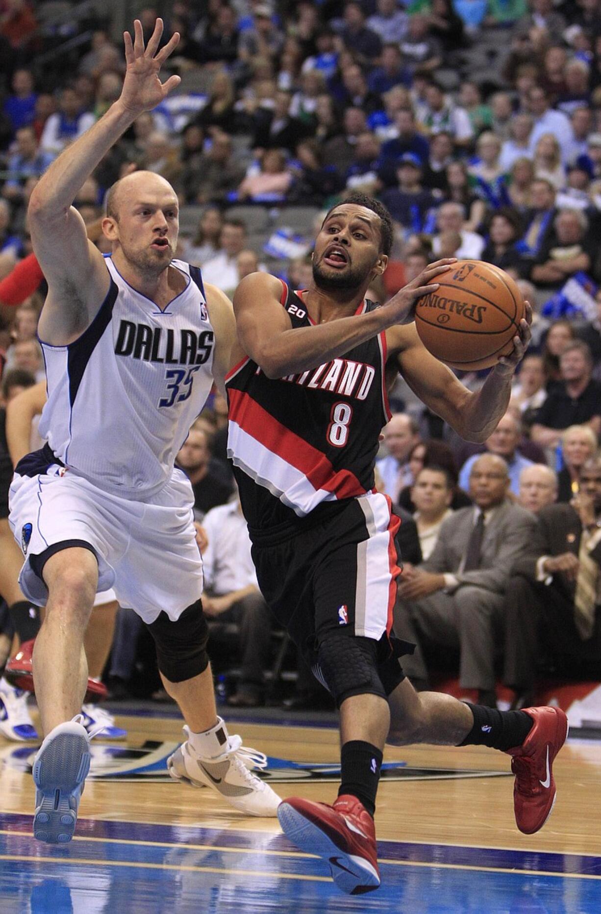 Trail Blazers point guard Patrick Mills (8) drives past Dallas Mavericks power forward Brian Cardinal (35) during the first half of a NBA basketball game in Dallas,  Tuesday, Jan. 4, 2011.