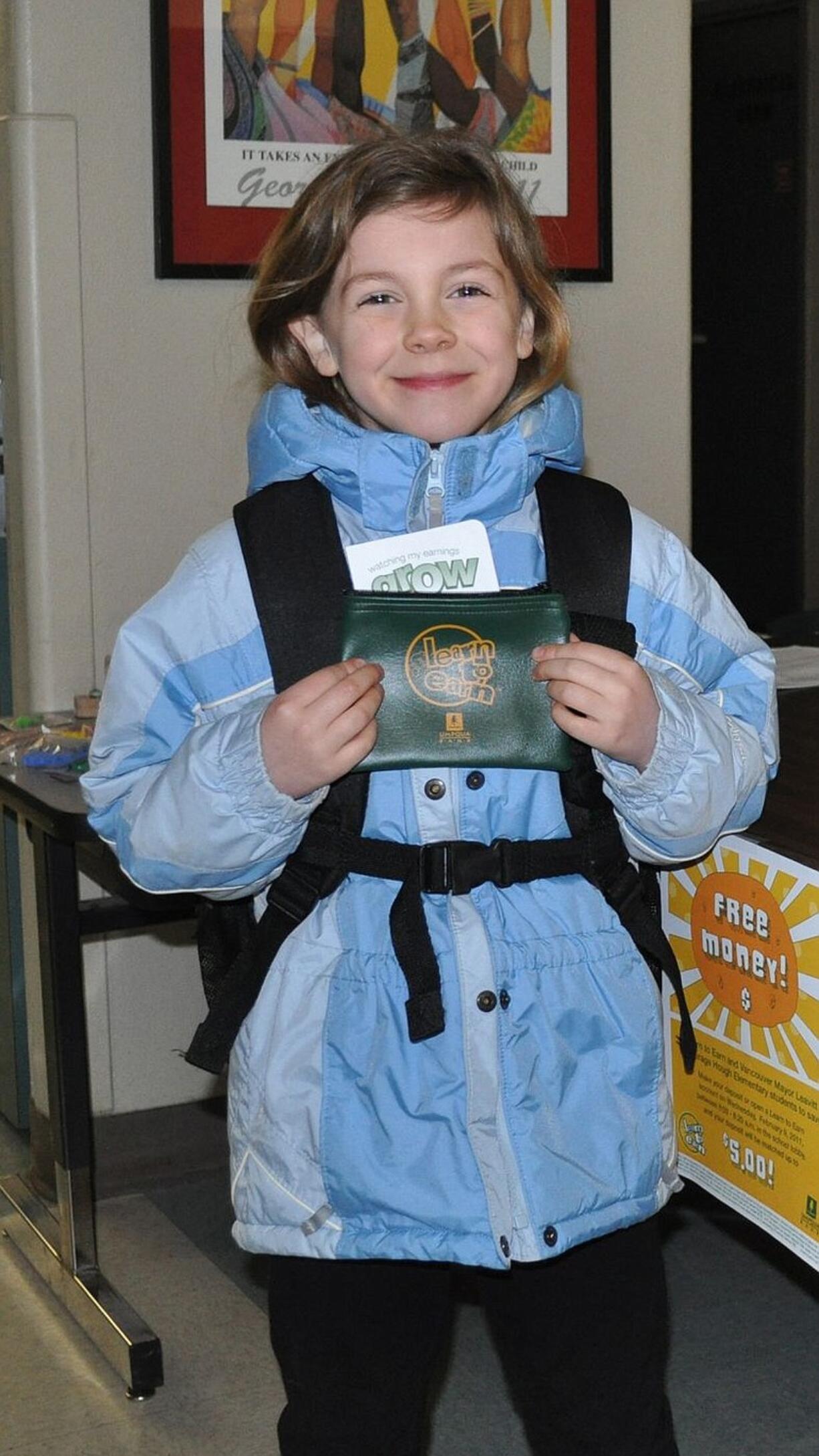 Hough Elementary School student Madison Pellico shows off her savings packet Feb.