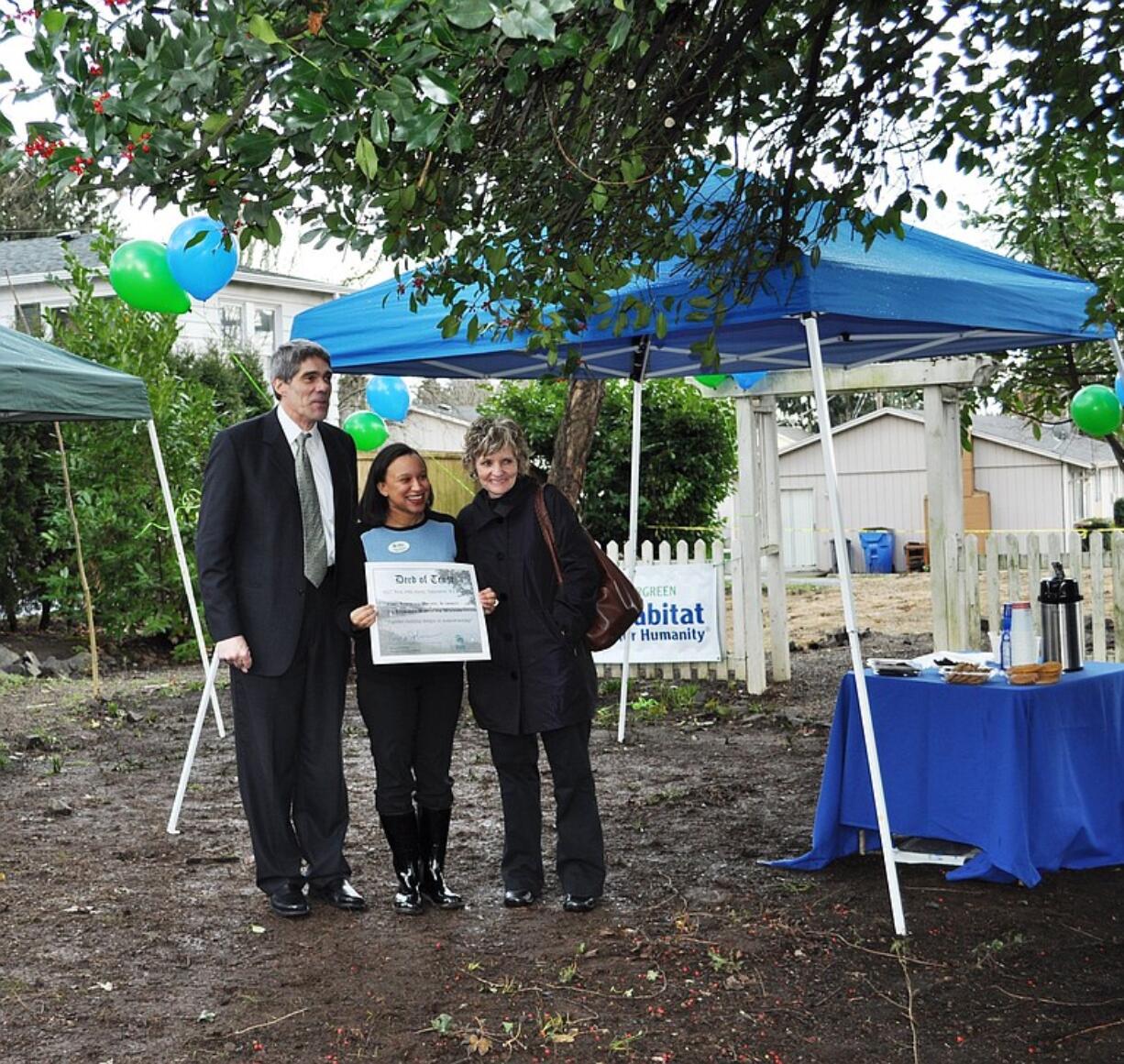 Vancouver Housing Authority Executive Director Roy Johnson hands ownership of vacant property on West 39th Street to Evergreen Habitat for Humanity's Kristina Aitchison.