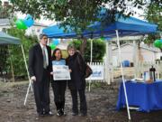 Vancouver Housing Authority Executive Director Roy Johnson hands ownership of vacant property on West 39th Street to Evergreen Habitat for Humanity's Kristina Aitchison.