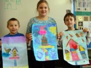 Tukes Valley Primary second-graders, from left, Trevor Sarkinen, Laura Peldo and Michael Piazza, hold up their artwork that will be on display in a help-the-birds exhibit opening Wednesday evening and running one week.