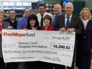 Fred Meyer officials present a check for more than $10,000 to Legacy Salmon Creek Medical Center representatives at Fred Meyer's Salmon Creek store.