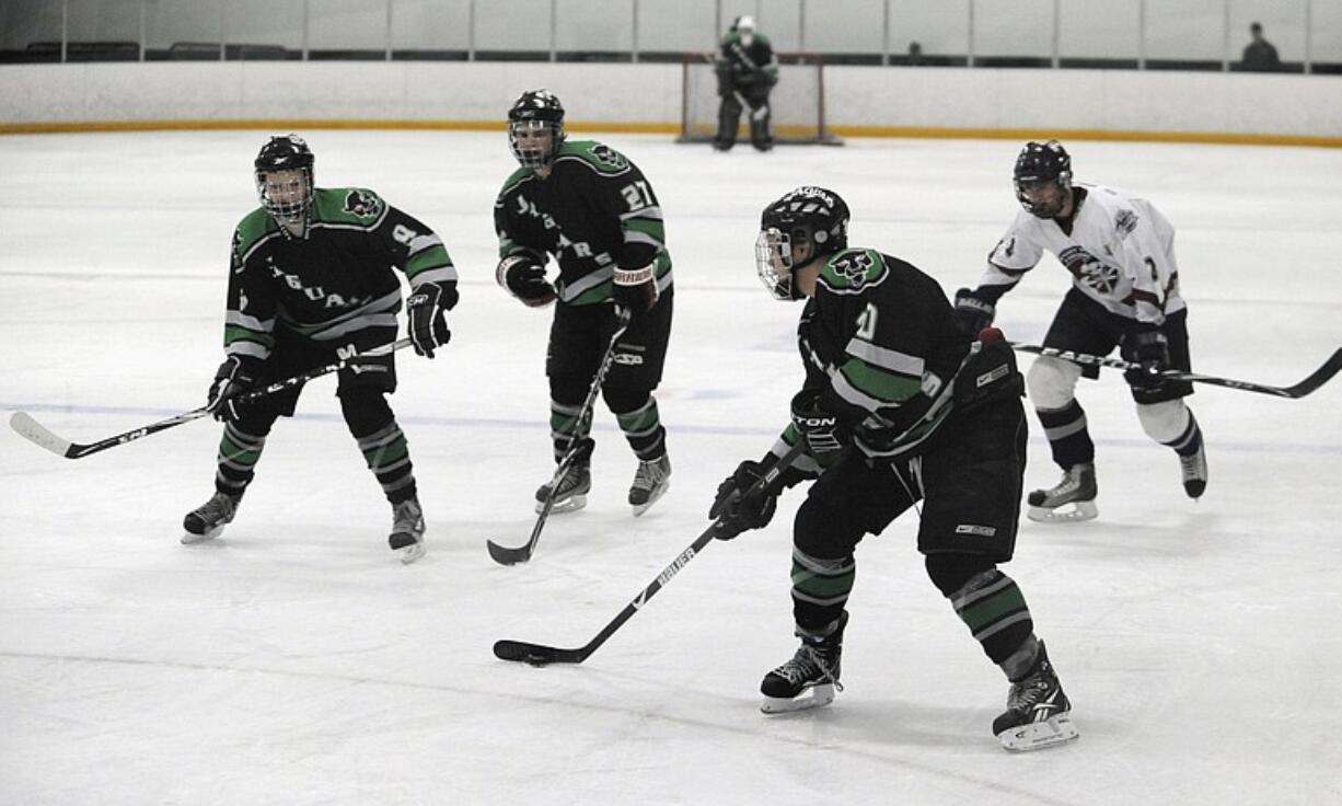 Brothers, from left, Avik Bordak (9) Elijah Bordak (27), and Joe Bordak (10) attack the goal against Puget Sound at Mountain View Ice Arena.