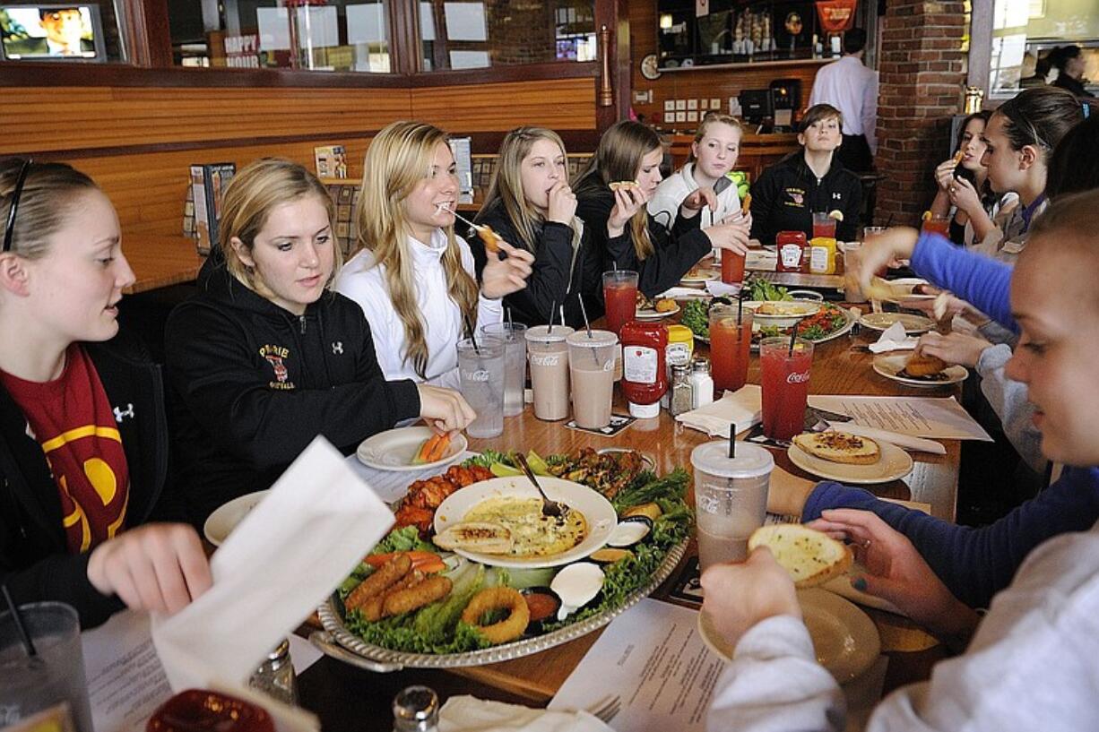 The Prairie girls basketball team enjoy a team meal sponsored by the the Tacoma Athletic Commission at the Class 3A state tournament.