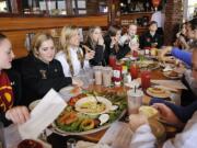 The Prairie girls basketball team enjoy a team meal sponsored by the the Tacoma Athletic Commission at the Class 3A state tournament.