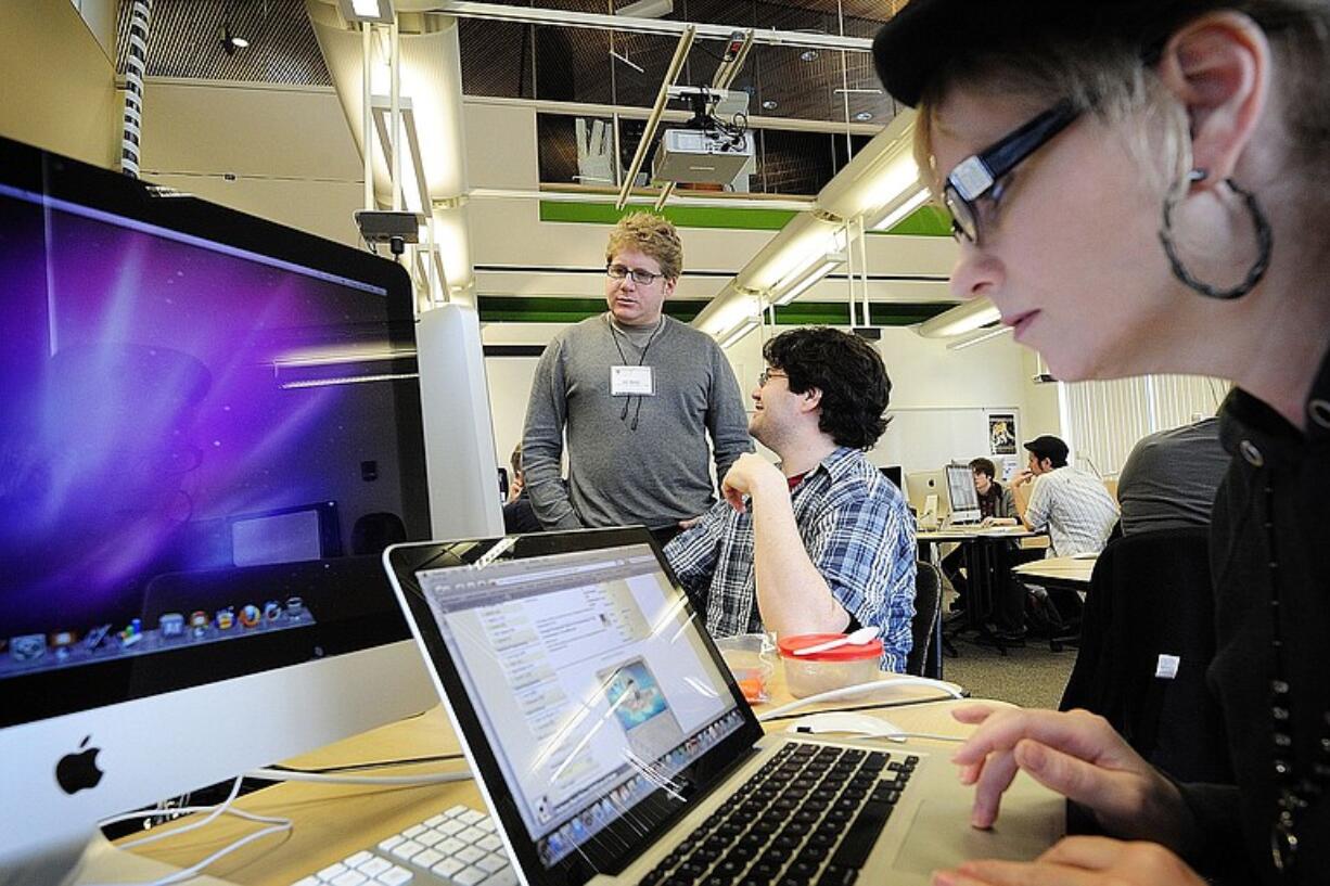 Lonni Hurst, foreground, works on a class project as Josh Neufeld, author of &quot;A.D.: New Orleans After the Deluge,&quot; visits with classmate Andrew DiZinno, center, at Washington State University Vancouver on Tuesday.