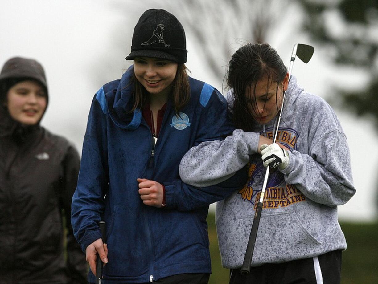 Columbia River High School golfers  Chloe Bartek (L) and Kira Kallem (R), both sophomores, brace against the wind and rain at Tri Mountain Golf Course in Ridgefield after cancelled match on Tuesday.