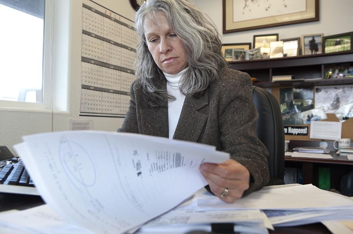 Sheila Miklos, a controller at 3 Kings Environmental, looks through the file of a workers' comp claim she believes is fraudulent.