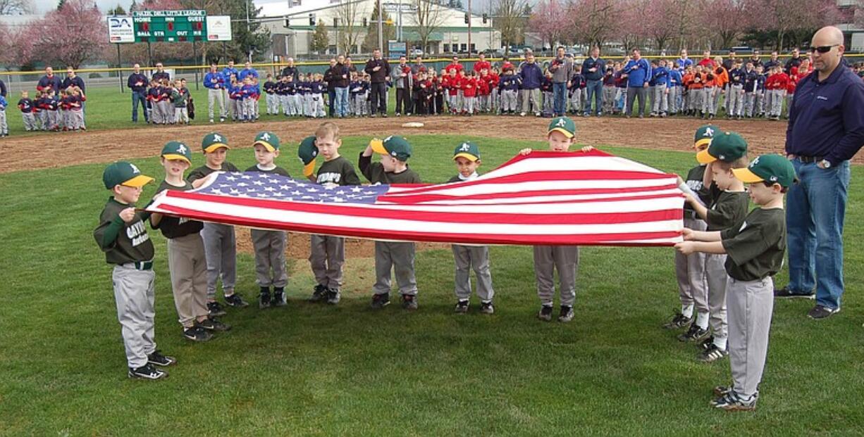 The A's T-ball team holds the flag March 19 during the opening ceremony of the Hazel Dell Little League season.