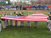 The A's T-ball team holds the flag March 19 during the opening ceremony of the Hazel Dell Little League season.