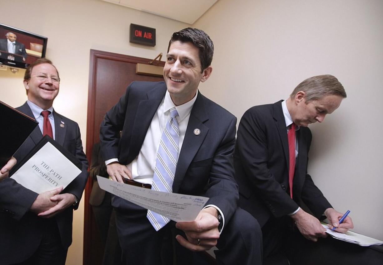 House Budget Committee Chairman Paul Ryan, R-Wis., center, flanked by committee members, Rep. Tom McClintock, R-Calif., right, and Rep.