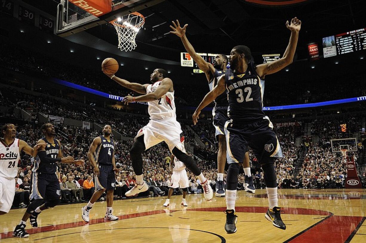 Wesley Matthews, 2, of the Portland Trail Blazers scores a basket as he drives between Memphis Grizzlies defenders Leon Powe, 7, and O.J. Mayo, 32, Tuesday April 12, 2011 at the Rose Garden in Portland, Oregon.