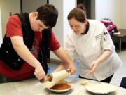 Washington State School for the Blind student Mike Timm from Oroville and Chef Jody Berrigan from Willow Gardens Retirement Home in Puyallup put the top crust a pie.