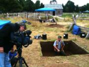 Doug Wilson, down in the dirt and playing to the camera, has won a National Park Service award for archaeology.