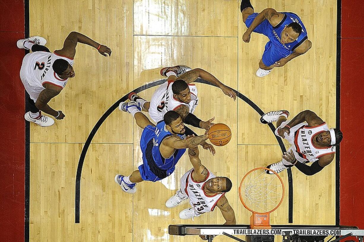 Portland's LaMarcus Aldridge, center top, and Marcus Camby (23) battle Dallas' Tyson Chandler (6) during the first half at the Rose Garden.