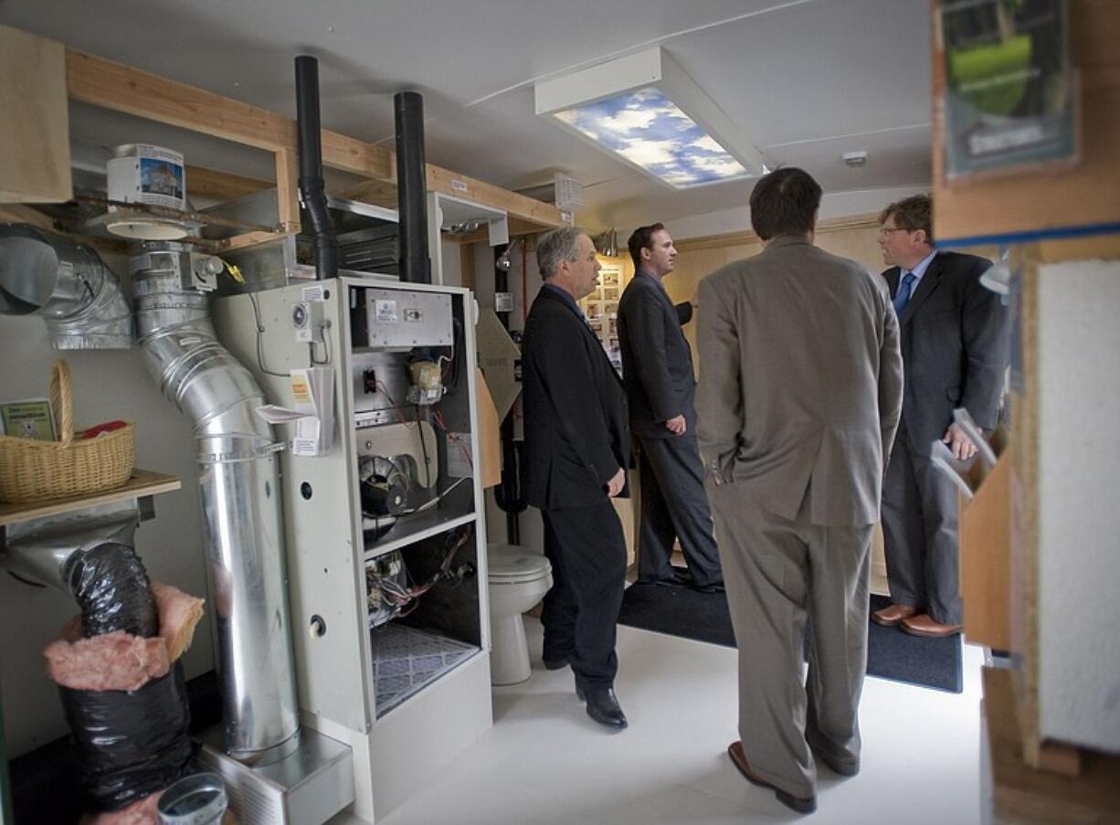 County Commissioners Marc Boldt, from left, and Steve Stuart get a tour from Clark County Chief Building Official Jim Muir and Clark County Energy-Efficiency Services Coordinator Mike Selig of the Planet Clark trailer.