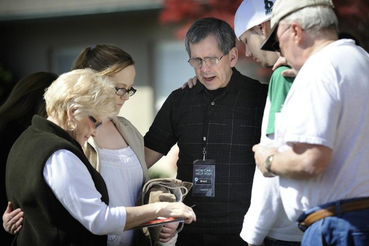 Brent Stahl, center, a member of City Harvest Church, offers a prayer with, from left, Pat Winn, Jennifer Zimmerman and her boyfriend, Jake Protasiewicz, and Jim Winn.