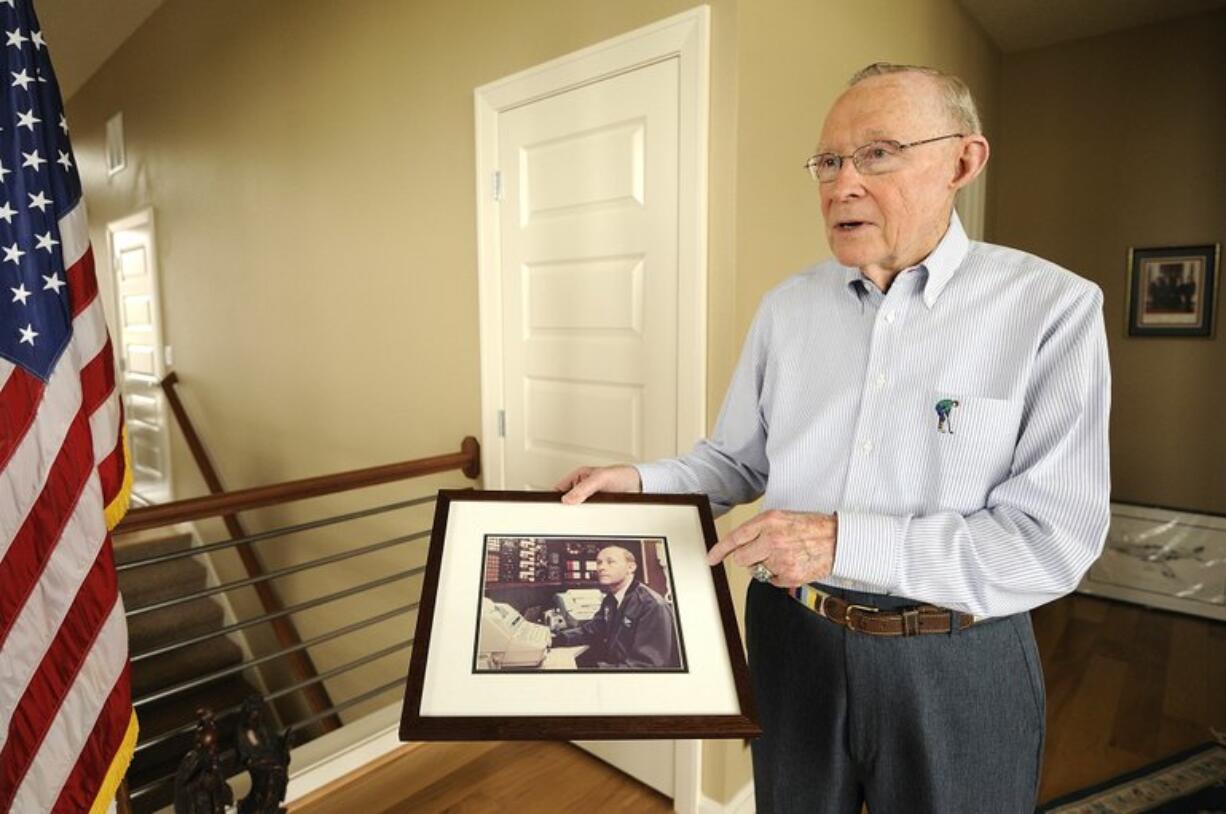 E.E. Van Valkenberg holds a photo showing him on duty at the communications console on Air Force One. It was his job to help several U.S.