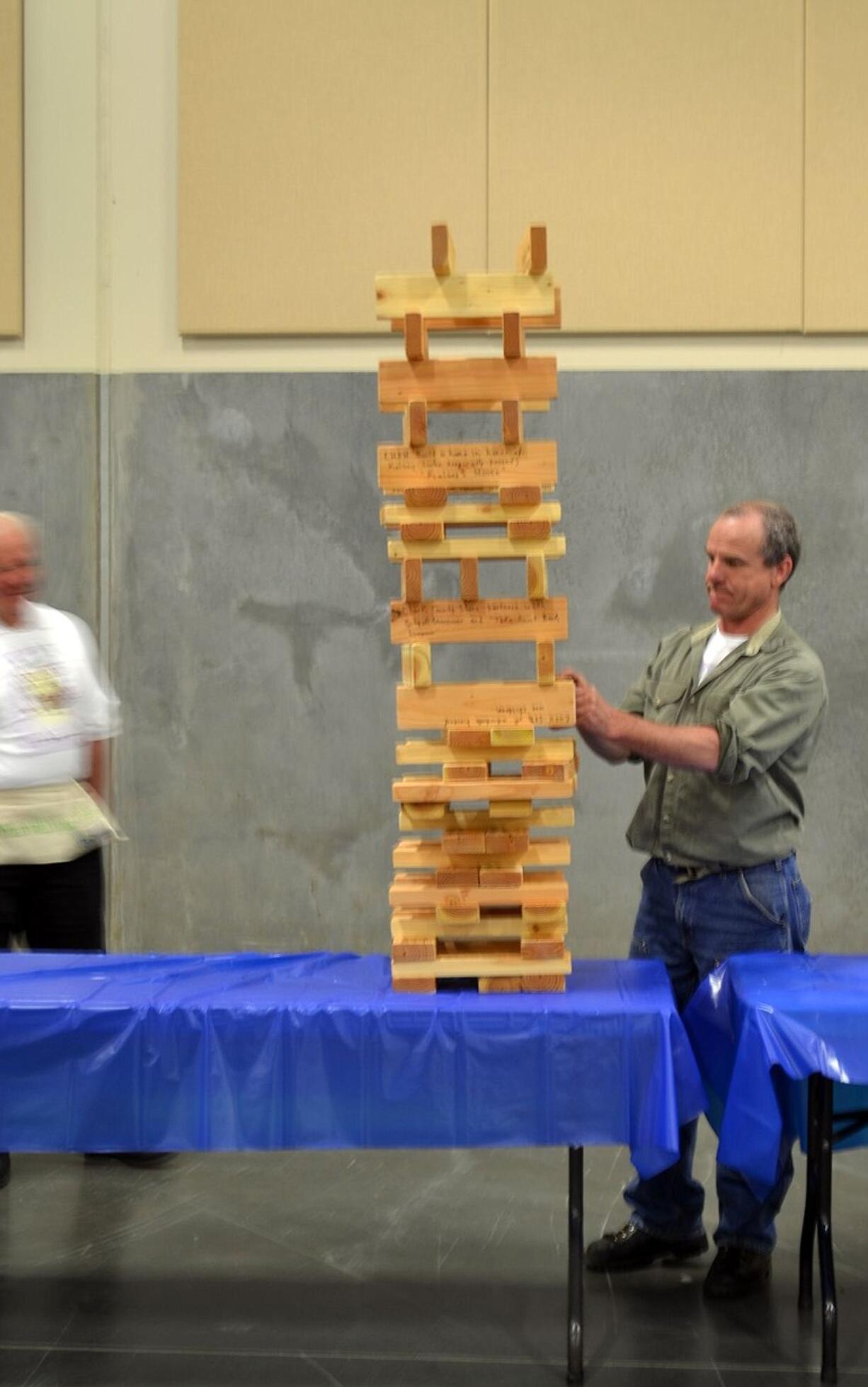 Gary Acton plays giant Jenga at the Evergreen Habitat for Humanity Tool Box Bash.