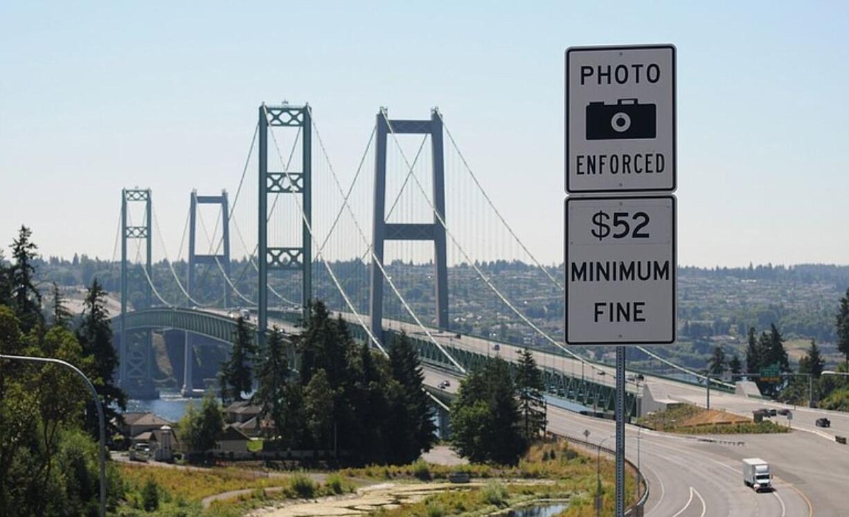 Signs warn drivers of the consequences of not paying tolls at the Tacoma Narrows Bridge.