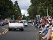 A passenger waves from the back seat of a convertible near the Main Street DQ during the third annual &quot;Cruisin' the Gut.&quot; Cars and crowds packed the Vancouver arterial, from early Saturday afternoon until well into evening.