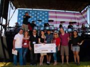 Lydia Moynihan, CAM High School, center, holds the trophy and check she won in the Sing Fourth contest.