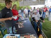 Vancouver driver Greg Biffle, left, signs a hat for Vancouver fan J.B. Selkregg during Wednesday's event at Portland International Raceway.