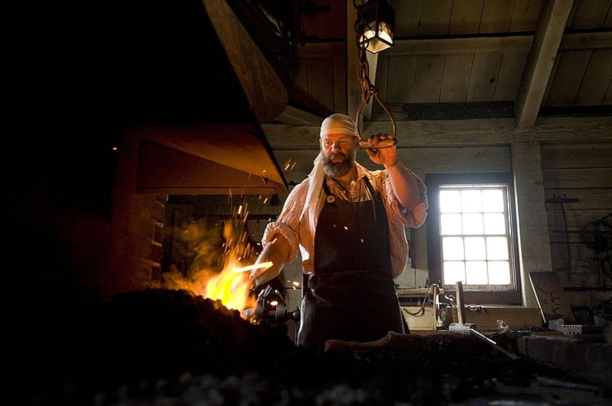 Stoking the fire at the blacksmith shop at the Fort Vancouver National Historic Site, Lee Pisarek prepares to work with some hot iron.