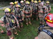 Capt. Jeff Gaines, right, points out a home's key features to a group of firefighter recruits before the live fire exercise. Recruits will graduate from training on Nov.